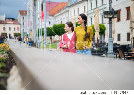 Mother and daughter walking in town and talking. 139379471
