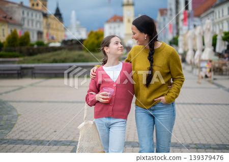 Mother and daughter walking in town and talking. Mother and daughter walking in town and talking. 139379476