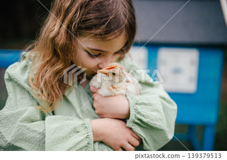 Girl taking care of chicken in family farm. Girl taking care of chicken in family farm. 139379513
