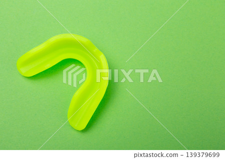 Professional gum shield for contact sports on a bright green background with copy space. 139379699