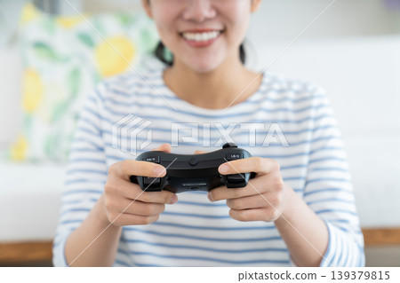 Young woman playing games in the living room Young woman playing games in the living room 139379815