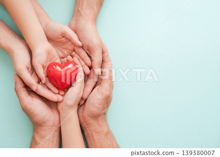 A red heart held in the hands of family members A red heart held in the hands of family members 139380007