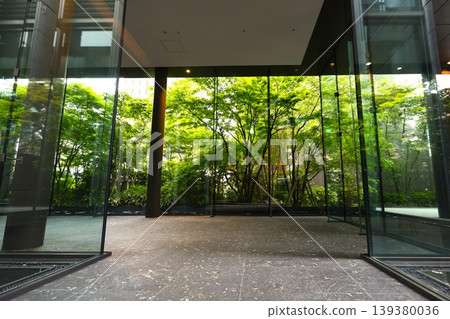 The entrance space of a luxury apartment building harmonizes with the surrounding greenery. The entrance space of a luxury apartment building harmonizes with the surrounding greenery. 139380036