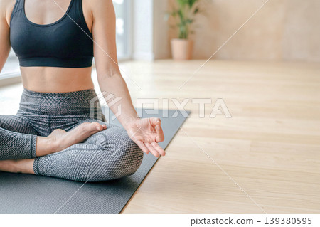 一位女子在燈光明亮的房間裡冥想。 139380595