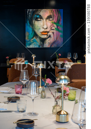 Elegant art dinner. Refined restaurant ambiance featuring vibrant portraits and sophisticated table setup Elegant art dinner. Refined restaurant ambiance featuring vibrant portraits and sophisticated table setup 139380788