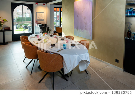 Elegant table with garden view. Serene setting featuring stylish furnishings and view of greenery Elegant table with garden view. Serene setting featuring stylish furnishings and view of greenery 139380795