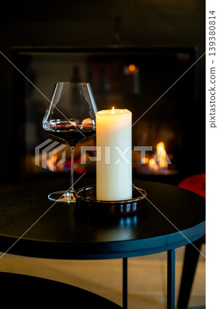 Wine candle ambiance. An intimate setting featuring glass of red wine and candle glow Wine candle ambiance. An intimate setting featuring glass of red wine and candle glow 139380814