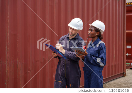Professional industrial workers checking inventory on electronic device and clipboard for supply chain management at an Asian shipping terminal Professional industrial workers checking inventory on electronic device and clipboard for supply chain management at an Asian shipping terminal 139381036
