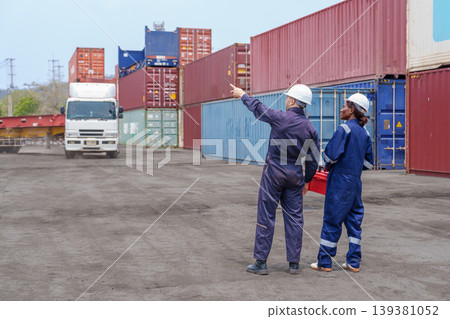 Mid-adult Caucasian Male and Black Female Logistics Workers Coordinating Cargo at Terminal 139381052