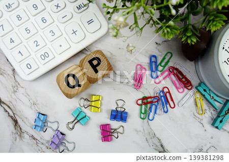 QP (Qualified Purchaser) alphabet letters with calculator and alarm clock on marble background QP (Qualified Purchaser) alphabet letters with calculator and alarm clock on marble background 139381298
