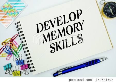 Develop Memory Skills text message written on notepad with stationery flat lay on white background Develop Memory Skills text message written on notepad with stationery flat lay on white background 139381392