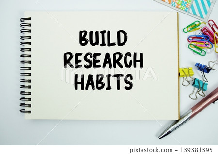 Build Research Habits text message written on notepad with stationery flat lay on white background Build Research Habits text message written on notepad with stationery flat lay on white background 139381395