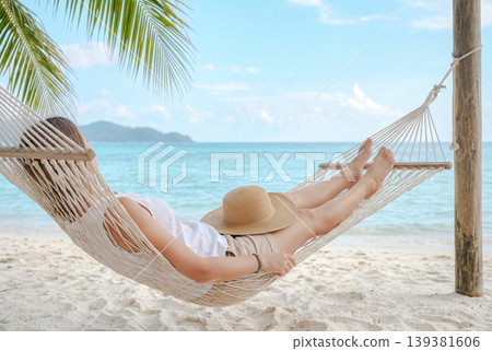 A woman relaxing in a hammock on a tropical beach. 139381606