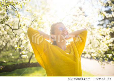 Happy Woman Enjoying Fresh Air in a Blooming Spring Park Happy Woman Enjoying Fresh Air in a Blooming Spring Park 139381953