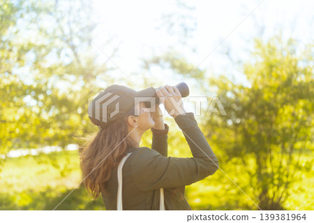 Enthusiastic Woman Birding in Sunlit Forest Enthusiastic Woman Birding in Sunlit Forest 139381964