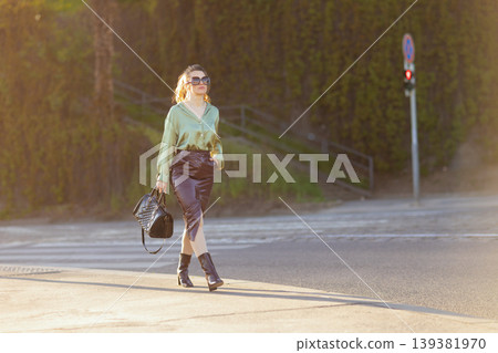 Fashionable Woman in Green Blouse Walking on City Street Fashionable Woman in Green Blouse Walking on City Street 139381970