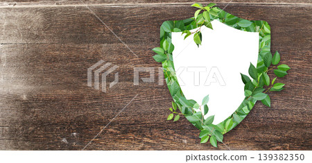 Horizontal wooden background with shield made from green leaves. Safety, global ecological resource, go green concept. Environmental conservation, wildlife protection, Eco-friendly, Green energy Horizontal wooden background with shield made from green leaves. Safety, global ecological resource, go green concept. Environmental conservation, wildlife protection, Eco-friendly, Green energy 139382350