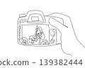 Minimalist one line drawing of a hand holding a digital camera showing a butterfly in public park. This nature concept is an amazing choice for Nature Photography Day coloring pages and wall decors. 139382444