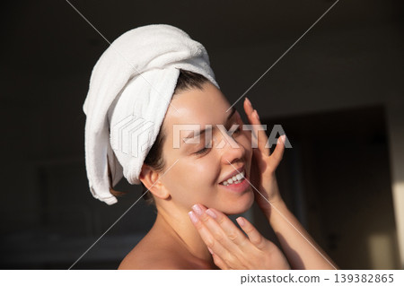 Pretty woman smiling while touching soft skin, fresh glow after shower, towel wrapped hair, natural beauty portrait, skincare wellness concept, daily routine, radiant healthy lifestyle Pretty woman smiling while touching soft skin, fresh glow after shower, towel wrapped hair, natural beauty portrait, skincare wellness concept, daily routine, radiant healthy lifestyle 139382865