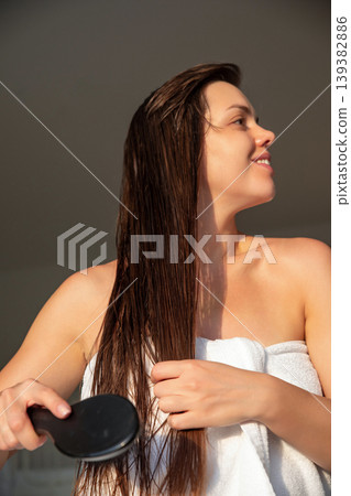 Female model brushing long wet hair with smooth motion in sunlight, beauty haircare routine at home, attractive woman with healthy shine and natural skin, wellness lifestyle concept Female model brushing long wet hair with smooth motion in sunlight, beauty haircare routine at home, attractive woman with healthy shine and natural skin, wellness lifestyle concept 139382886