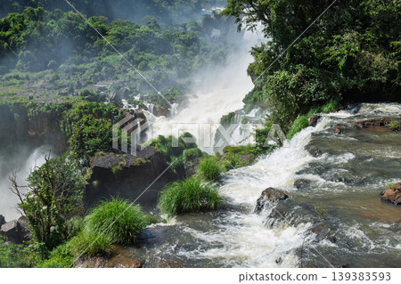 Majestic awe and wild power of iguazu falls waterfall surging in vivid green nature landscape Majestic awe and wild power of iguazu falls waterfall surging in vivid green nature landscape 139383593