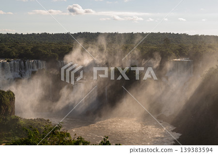 Majestic iguazu falls rushing powerful water creating dramatic mist in an inspiring landscape Majestic iguazu falls rushing powerful water creating dramatic mist in an inspiring landscape 139383594