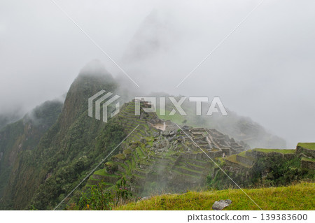 Majestic ancient machu picchu ruin appears peaceful in mysterious fog on green mountain Majestic ancient machu picchu ruin appears peaceful in mysterious fog on green mountain 139383600