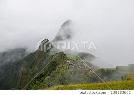 Mysterious machu picchu mountain peak hidden by heavy fog and ancient ruin Mysterious machu picchu mountain peak hidden by heavy fog and ancient ruin 139383602