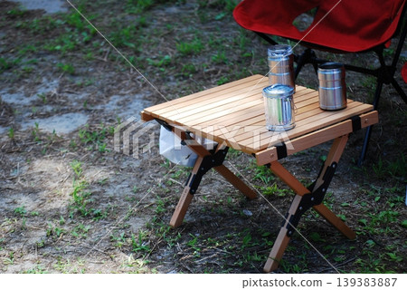 A wooden folding table and beverage cans placed outdoors A wooden folding table and beverage cans placed outdoors 139383887