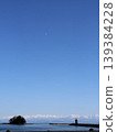 A landscape of the sea and snow-capped mountains with the moon shining in the sky. 139384228