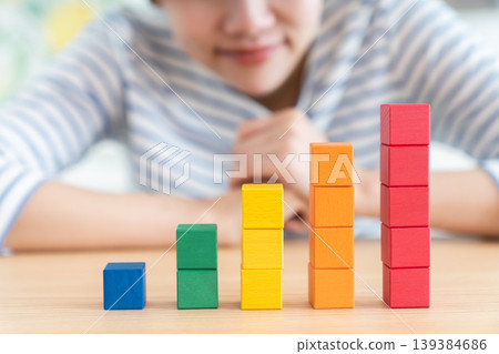 A young woman looking at building blocks 139384686