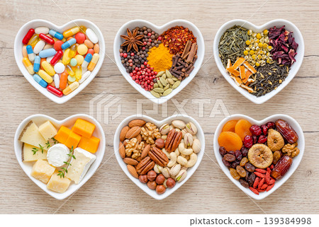 A set of medicines and food items in a heart-shaped container. A set of medicines and food items in a heart-shaped container. 139384998
