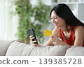 Happy asian woman buying online with card at home 139385728