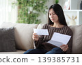 Sad asian woman reading a paper letter at home 139385731