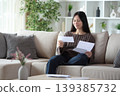 Satisfied asian woman reading letter on a couch at home 139385732