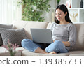 Satisfied asian woman using personal computer sitting at home 139385733