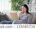 Thoughtful asian woman reading carefully a document at home 139385734