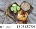 At its heart lies an artisanal ham and cheese toastie, crowned with a molten, bubbling layer of fromage. Expertly charred, its surface offers a sophisticated contrast between creamy gold and deep, 139385759