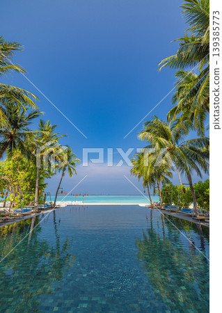 Luxury tropical swimming pool with palm trees and a stunning ocean view perfect for an exotic summer travel vacation background and copy space design Luxury tropical swimming pool with palm trees and a stunning ocean view perfect for an exotic summer travel vacation background and copy space design 139385773