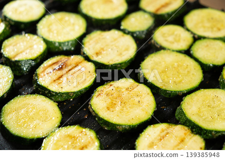 Close-up of Fresh Green Zucchini Rounds Roasting on Contact Grill. Close-up of Fresh Green Zucchini Rounds Roasting on Contact Grill. 139385948