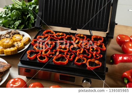 Cooking sweet peppers on an electric grill 139385985
