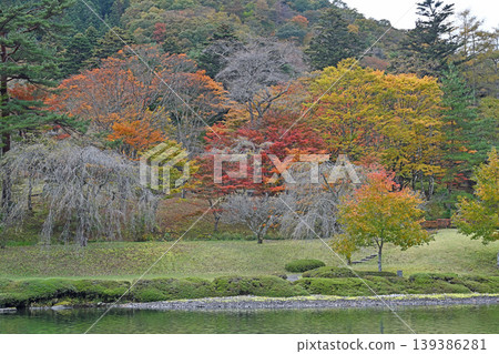 秋色裝飾著山麓;絢麗的秋葉和寧靜的日式花園沿著湖岸綿延展開。 秋色裝飾著山麓;絢麗的秋葉和寧靜的日式花園沿著湖岸綿延展開。 139386281