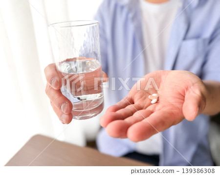 Middle-aged man taking medicine Middle-aged man taking medicine 139386308