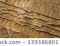 Tire tracks pattern on brown muddy dirt ground 139386801