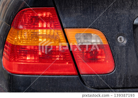 Car headlights covered in dirt reveal the lack of car maintenance in a busy urban area under natural light conditions Car headlights covered in dirt reveal the lack of car maintenance in a busy urban area under natural light conditions 139387193