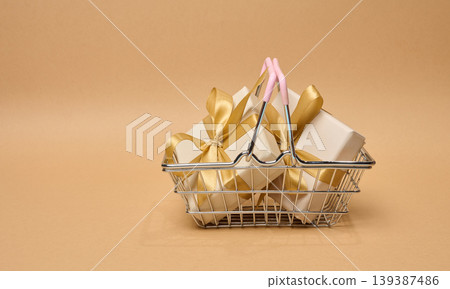 A stack of boxes tied with a golden ribbon on a beige background A stack of boxes tied with a golden ribbon on a beige background 139387486