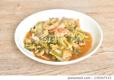 fried seafood with chicken and pork meat couple vegetable toping egg yolk in sukiyaki sauce on plate 139387533