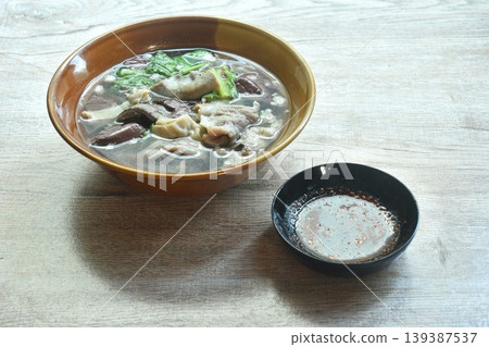 boiled pork blood and entrails with chop pork topping lettuce in soup on bowl dipping spicy sour chili sauce boiled pork blood and entrails with chop pork topping lettuce in soup on bowl dipping spicy sour chili sauce 139387537