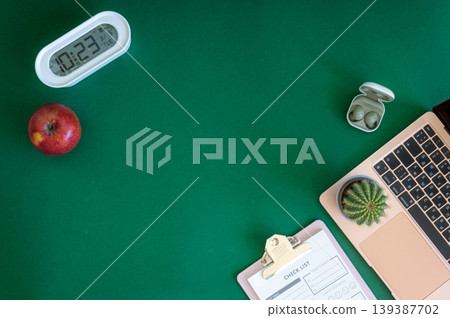 A vibrant assortment of school supplies including notebooks, pencils, markers, and scissors neatly arranged on a green background A vibrant assortment of school supplies including notebooks, pencils, markers, and scissors neatly arranged on a green background 139387702
