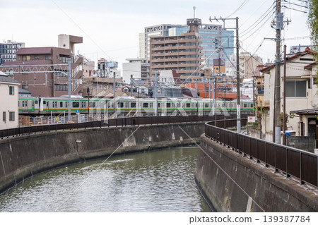 [Tokaido Main Line] A local train passing through the streets of Kamata in the early morning. 139387784